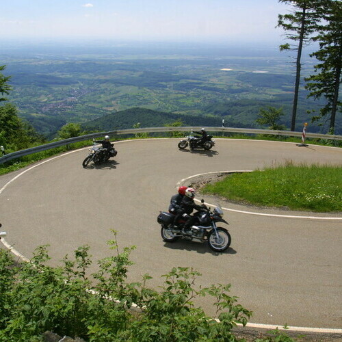 Motorradgruppe fhrt durch eine Kurve auf einer Strae im Schwarzwald