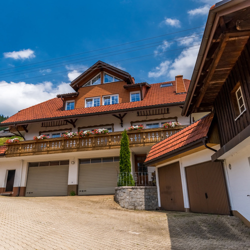 Die Rückseite des Hauses mit gepflastertem Hof und Garagen - 