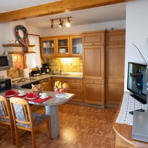 Esstisch und Küche mit Holzschränken - 