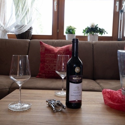 Eine Flasche Wein und zwei Weingläser stehen auf dem Couchtisch - 