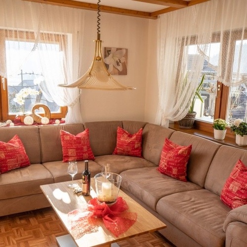 Eckcouch mit Couchtisch auf dem eine Flasche Wein und zwei Gläser stehen - 