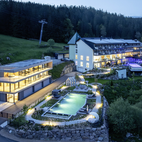 Außenansicht Belchenhotel Jägerstüble - Außenansicht des Belchenhotel Jägerstüble mit Außenpool und Beleuchtung in der Dämmerung 